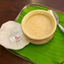 A serving platter with a bowl of delicious soup and a spoon is ready to be served and enjoyed.