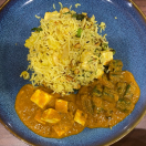 A plate of rice, vegetables, paneer gravy, and protein is a healthy and well-balanced meal choice.