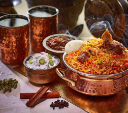 Indian chicken biriyani is presented elegantly on a table with an array of flavorful spices & sauces