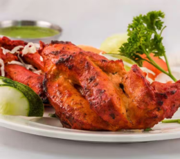 A platter of vegetables and Tandoori chicken served with a tasty dipping sauce on the side