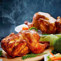 Delicious aroma and appetizing two whole roasted grilled crispy chickens on a plate with vegetables.