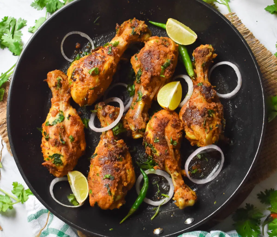 Decorated with slices of mint, onion, and lemon, chicken drumsticks deliver a yummy experience.