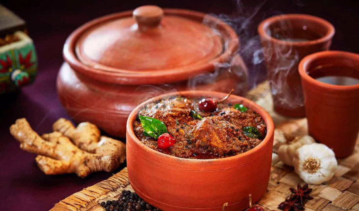 Bowls of food with a variety of spices and herbs and a dish that is garnished are placed on a table.