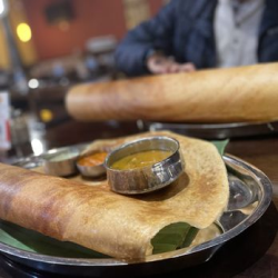 A plate with two huge dosa rolls, a usual vegetarian dish from South Indian tasty vegetarian food