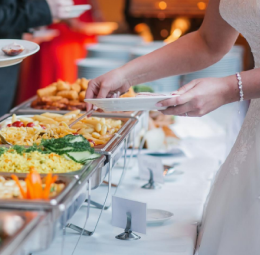 In a wedding atmosphere, a woman chooses colorful and delicious foods and places them on her plate.