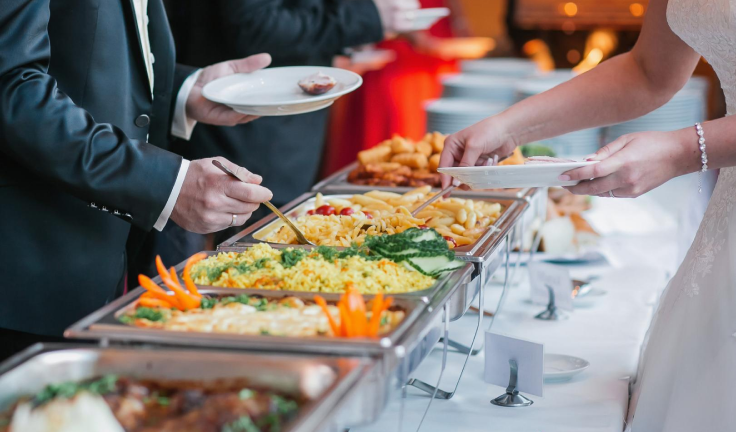 Guests are served a variety dishes with delight by newlyweds during their wedding reception .