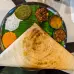 A platter filled with authentic varieties of chutney & served with a delicious dosa in a banana leaf