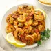 A hearty portion of a delicious prawn meal, enhanced with a zesty sauce and seasoned with lemon